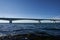 White Zeeland bridge in Holland, blue sea water and sky, sea algae in the foreground. Netherlands