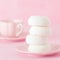 White zephyr dessrt on pink plate, cup of coffee with milk on pastel pink background. Beautiful sweets. Square banner, greeting ca