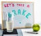 A whiteboard titled `Let`s take a brake` with red and green letters, cup of milk and a green apple.