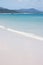 The Whitehaven Beach in the Whitsundays in Australia with a little boat in the distance