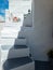 Whitewashed building empty narrow stone stairs at Kimolos island Greece. Vertical