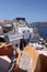 Whitewashed buildings and the ruins of Castle of Agios Nikolaos on the edge of the caldera cliff, Oia village, Santorini