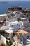 Whitewashed buildings and the ruins of Castle of Agios Nikolaos on the edge of the caldera cliff, Oia village, Santorini