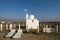 Whitewashed Greek Orthodox hermitage with a flag blowing in the wind