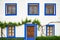 Whitewashed house facade with blue windows