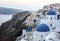 Whitewashed houses and blue dome church by the Aegean sea, Santoriniin Oia, Santorini, Greece. Famous blue domes in Oia village,