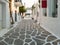 Whitewashed houses empty cobblestone alley at Naousa village, Paros island, Greece