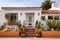 whitewashed spanish revival home facade with terracotta pots