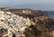 The whitewashed town of Fira in warm rays of sunset on Santorini island,