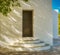 Whitewashed traditional church or hermita in a small village in Spain. Shadows cast over circular steps. Monochrome Diagonal light
