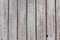 A whitewashed wooden surface worn out due to weather. Planks painted white. The texture of the wooden board