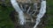 Whitewater Falls with falling down clear water from rocky boulders between green lush woods in Nantahala National Forest