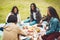 Who needs a refill. a group of cheerful young friends having a picnic together outside in a park during the day.