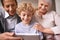 Who needs tech support when you have grandchildren. A little boy using a tablet while sitting with his grandparents.