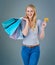 Who said money cant buy happiness. Cropped studio shot of a young woman holding up shopping bags and her credit card.