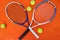 Who wants to challenge me. High angle shot of tennis essentials placed on top of an orange background inside of a studio