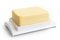 A whole block of butter on white plastic butter dish isolated on