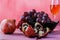 Whole and broken pomegranate and bunch red grape on a table
