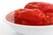 Whole canned tomatoes in white dish.