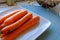 Whole carrots on a white ceramic plate landscape crop