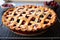 a whole cherry pie with a lattice crust on a baking rack