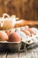 Whole chicken eggs in eggbox on wooden table