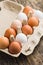 Whole chicken eggs in eggbox on wooden table