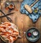 Whole chicken flattened out with meat hammer, spices and kitchen tools on wooden rustic background, cooking preparation , top view