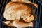 Whole chicken with spices rubbed in all over skin laying on rack of smoker ready to cook - close-up and selective focus