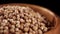 Whole cilantro seeds. Coriander grains in wooden rustic bowl on black background