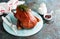 Whole crispy golden roast duck on a wooden plate