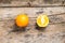 Whole and Cut in Half Orange lying on Weathered Wooden Table