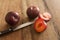 Whole and cut plums with knife on table