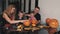 Whole family carves pumpkins for halloween on table at home