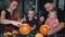 Whole family carves pumpkins for halloween on table at home