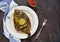 A whole flounder, baked in the oven, on a light plate on a brown concrete background. Fish recipes