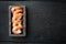 Whole fresh peeled cooked prawns, shrimps, in wooden box, on black wooden table background, top view flat lay , with copyspace