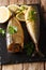 Whole freshly smoked mackerel served with lemons and parsley closeup on a slate board on the table. vertical