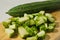 A whole gambas or luffa gourd and pieces of luffa gourd fruit on a wooden cutting board