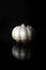 Whole garlic bulb with reflection on black background