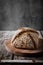 Whole grain baked bread on rustic wooden table. Freshly homemade bread