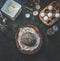 Whole grain bread baking preparation on dark rustic background. Bread dough with various nuts and seeds in wooden bowl with flour