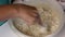 Whole grain flour is sifted into the basin and mineral water is poured. Woman kneads dough with a spoon.