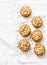 Whole grain mini muffins with dried apricots, oatmeal, apple, carrots and nuts on light background, top view