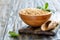 Whole grain oats in a bowl and wooden scoop.