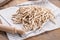 Whole grain wheat raw apulian pasta Pizzarieddi or maccaruni on a cotton napkin board on wooden table. Italian pasta