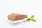 Whole and ground or crushed brown flax seed or linseed with grinder on white background