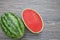 Whole and half watermelon on wooden background