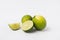 whole and halved limes laying on white