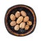 Whole and halved nutmeg seeds on a black plate cutout. Organic muscat seeds on a dish isolated on a white background. Dry fruits